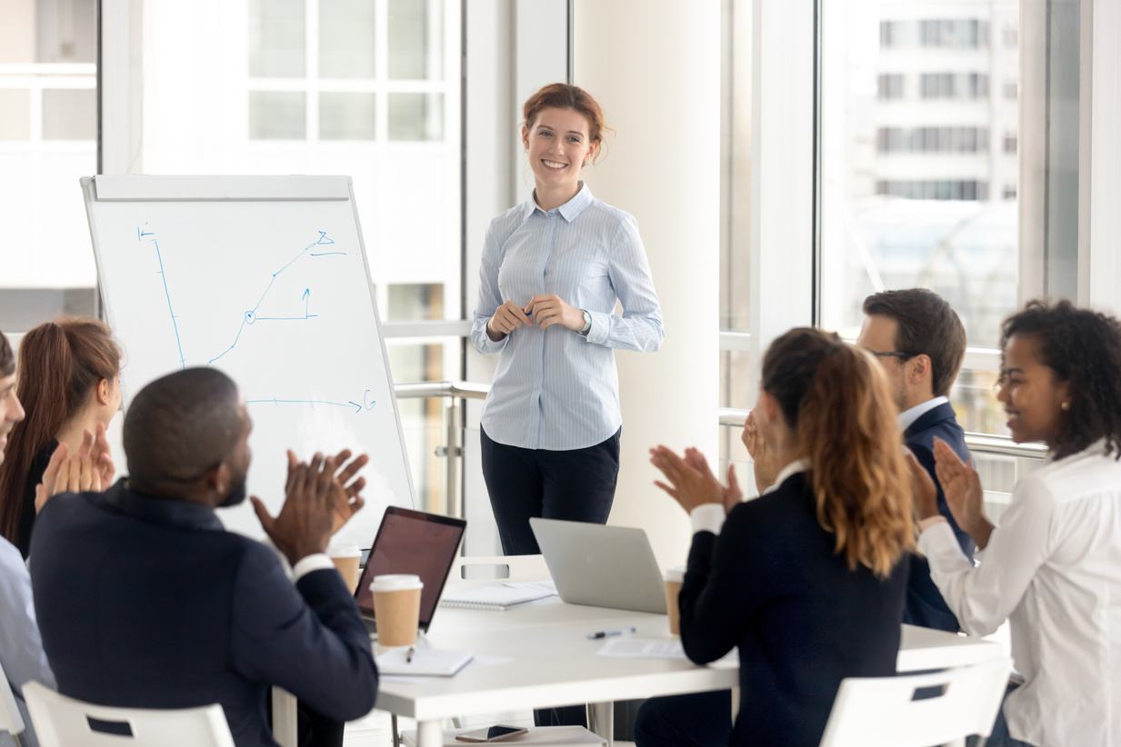 Diverse employees applaud thanking coach for training