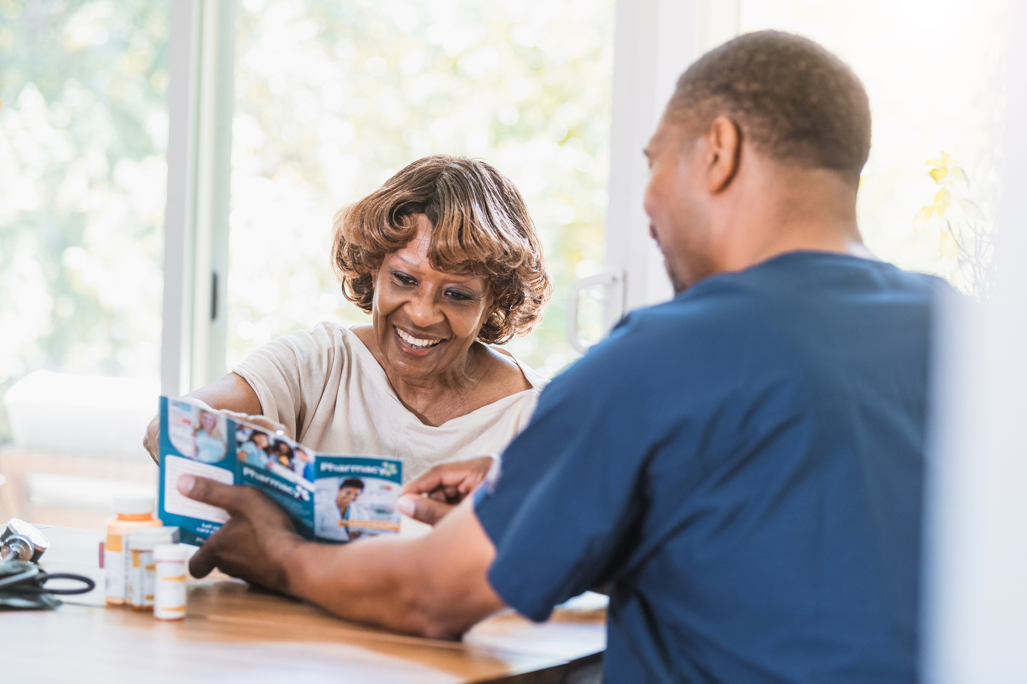 Home healthcare nurse shows patient healthcare services brochure