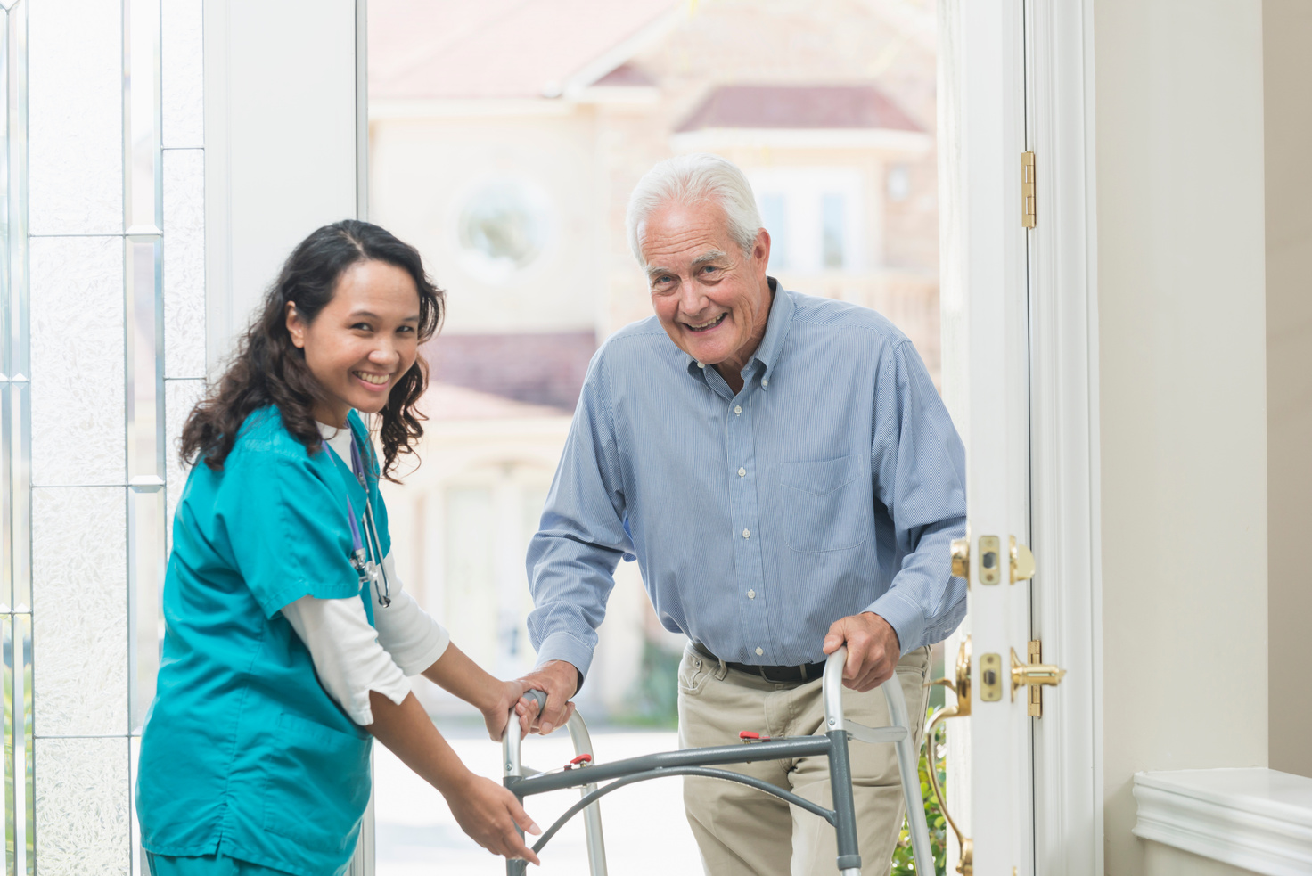 Home healthcare worker helping elderly man with walker